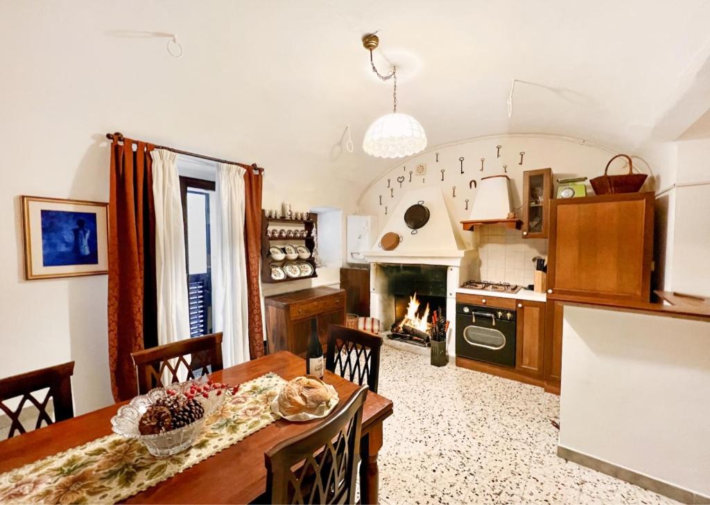 a kitchen and dining room with a table and a fireplace at I Due Gradoni Stone House in Pacentro