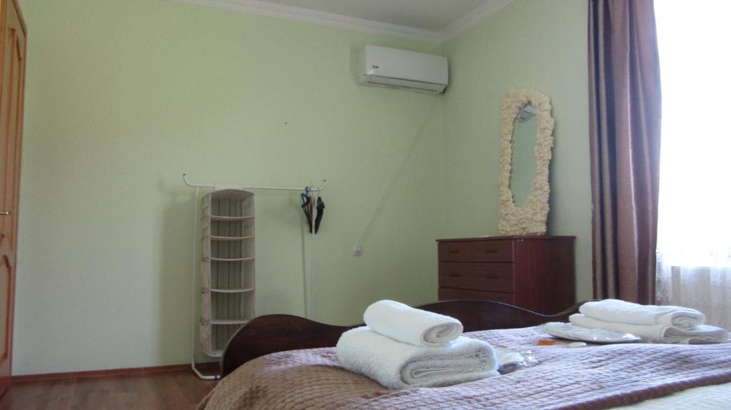 een slaapkamer met een bed met handdoeken erop bij Blue Guest House in Samtredia