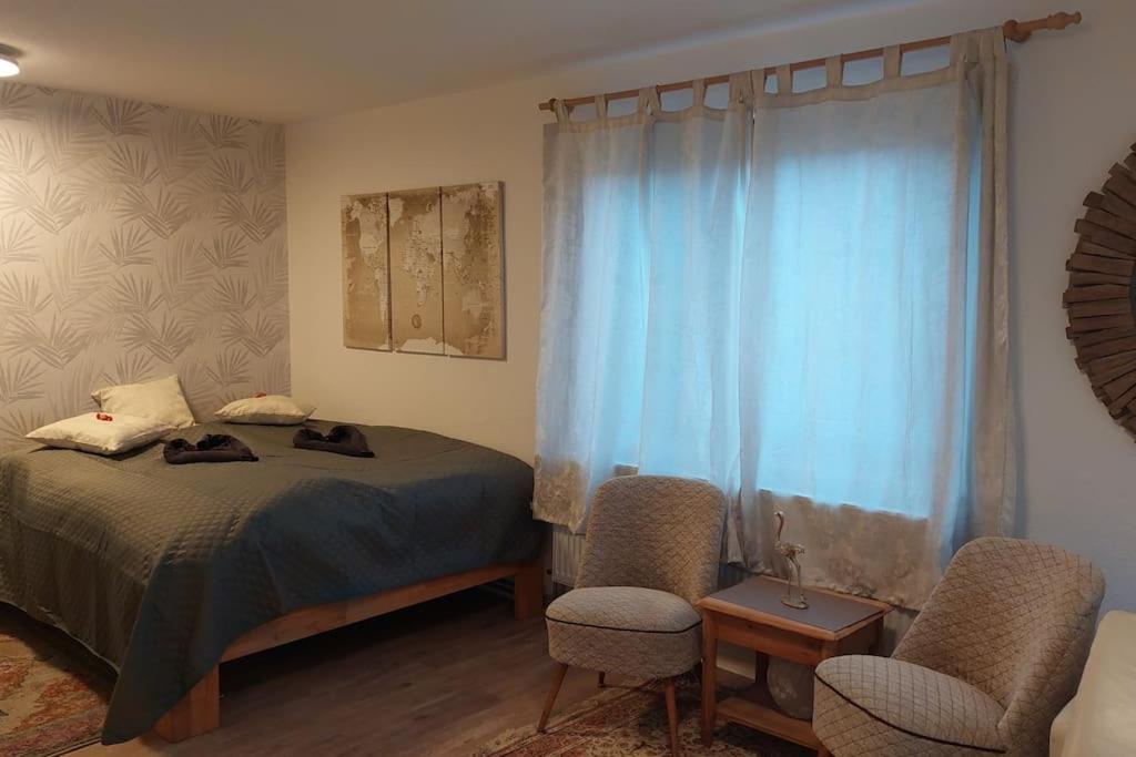 um quarto com uma cama e 2 cadeiras em Günstige, schöne Ferienwohnung im Wanderparadies em Wernigerode