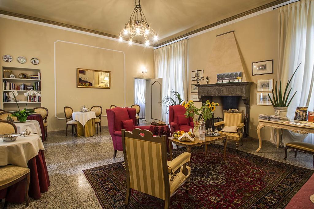 sala de estar con mesa, sillas y chimenea en Relais San Lorenzo, en Lucca