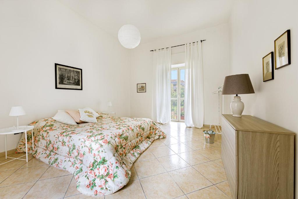 a bedroom with a bed and a table and a window at La casa di Ele 2-100 metri dalla Reggia in Caserta