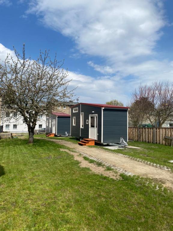 una casa con dos garaje en un patio en Tiny House 300 Meter vom Zentrum entfernt, en Eberswalde