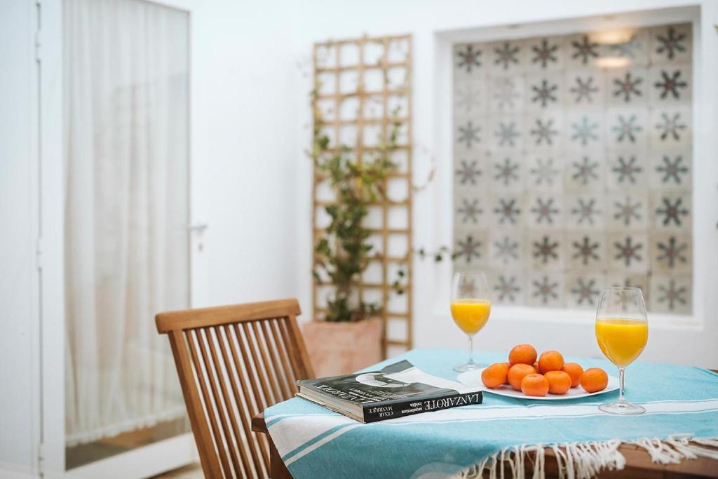 a table with a plate of oranges and two glasses of orange juice at Casa Morera - Best Villas Lanzarote in Teguise