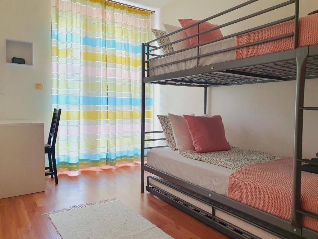 ein Schlafzimmer mit 2 Etagenbetten mit einem farbenfrohen Vorhang in der Unterkunft Trend Baláca Home in Veszprém