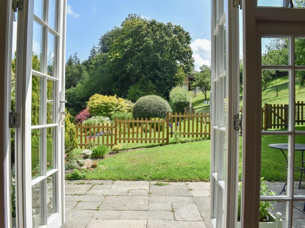 an open door to a garden with a fence at Umber House in Dean Prior