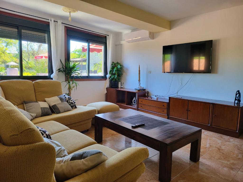 a living room with two couches and a flat screen tv at Alojamiento Pena da Osa in Sober