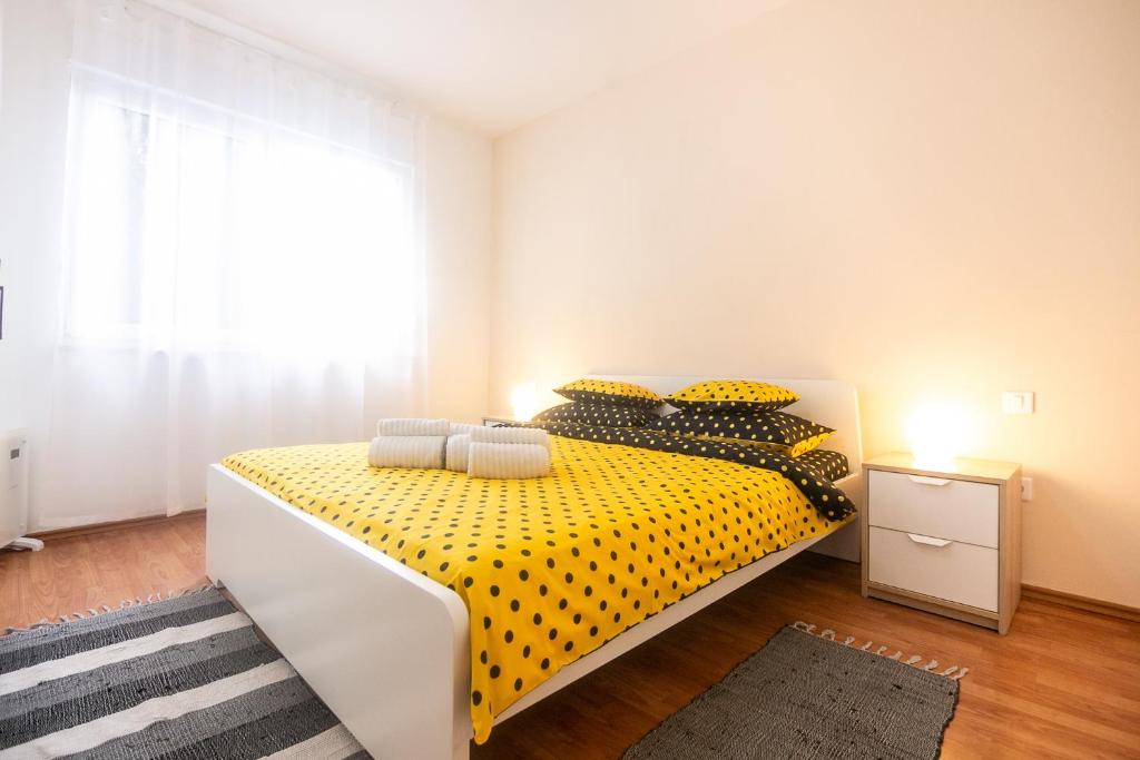 Un dormitorio con una cama amarilla y negra y una ventana en Apartment Noemi en Pula