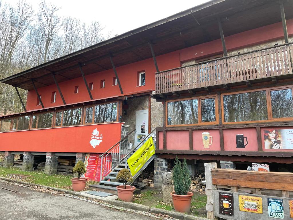 佩茲諾克的住宿－Chata Korenný vrch Pezinská Baba，一座红色的建筑,前面有植物