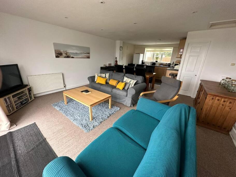 sala de estar con sofá azul y mesa en St Anns Cottage 9, en Gunnislake