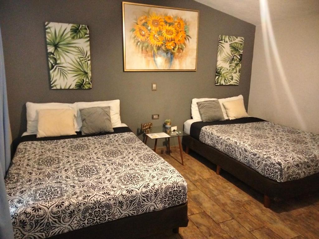 um quarto com duas camas e um quadro na parede em Abitare Durango By Grupo Salazar em Durango