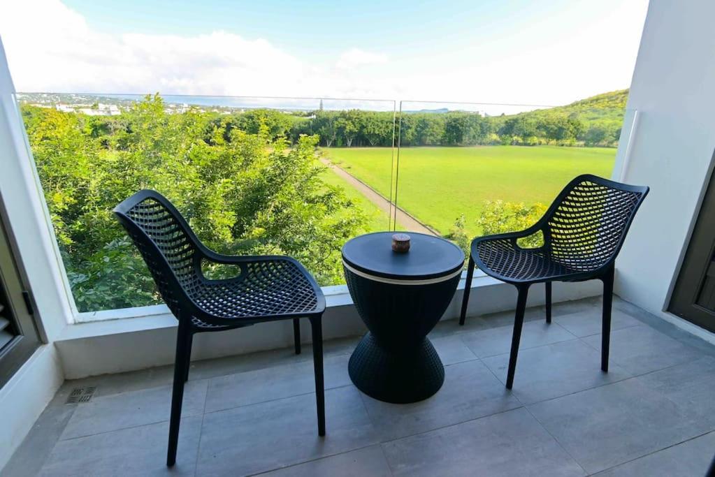 duas cadeiras e uma mesa em frente a uma janela em Home Sweet Home em Quatre Bornes