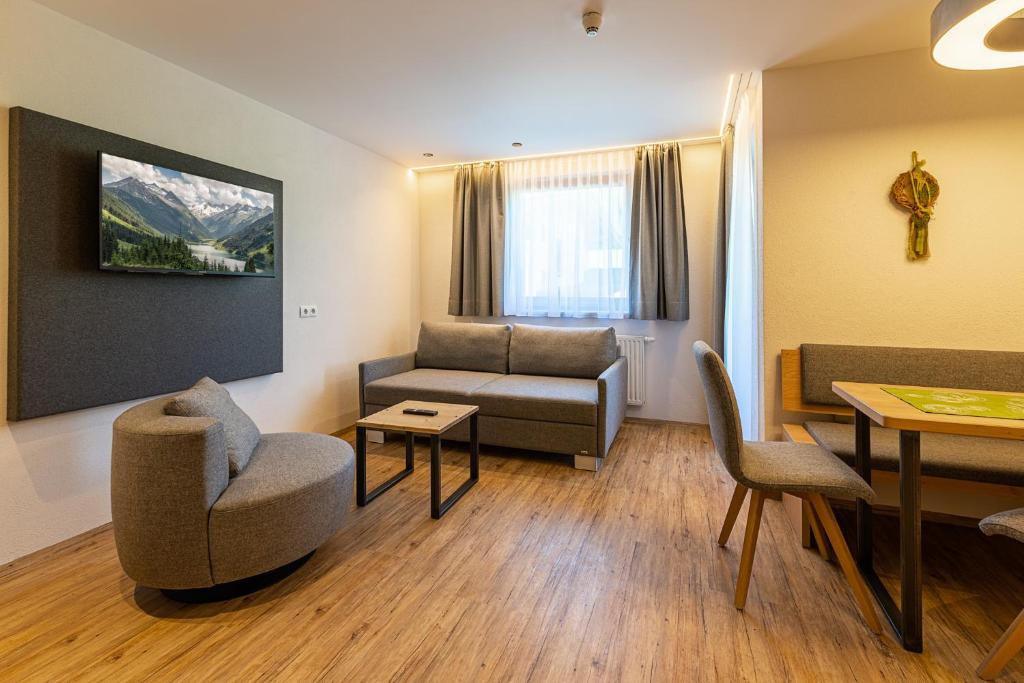 フューゲンにあるHotel Garni Romantikのソファとテーブルのあるリビングルーム