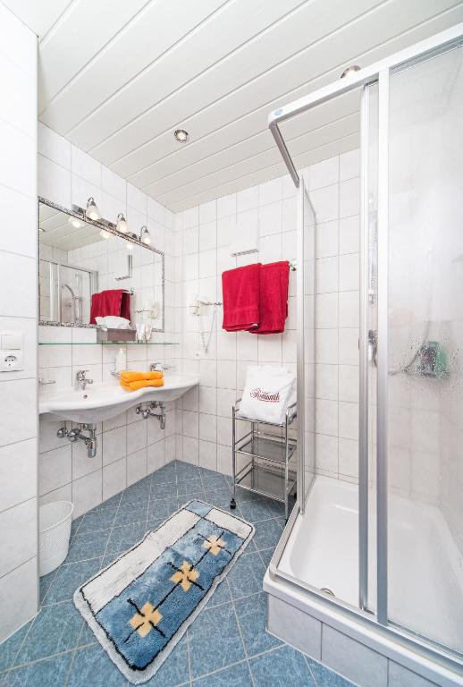 フューゲンにあるHotel Garni Romantikの浴槽、洗面台、シャワーを備えたバスルーム