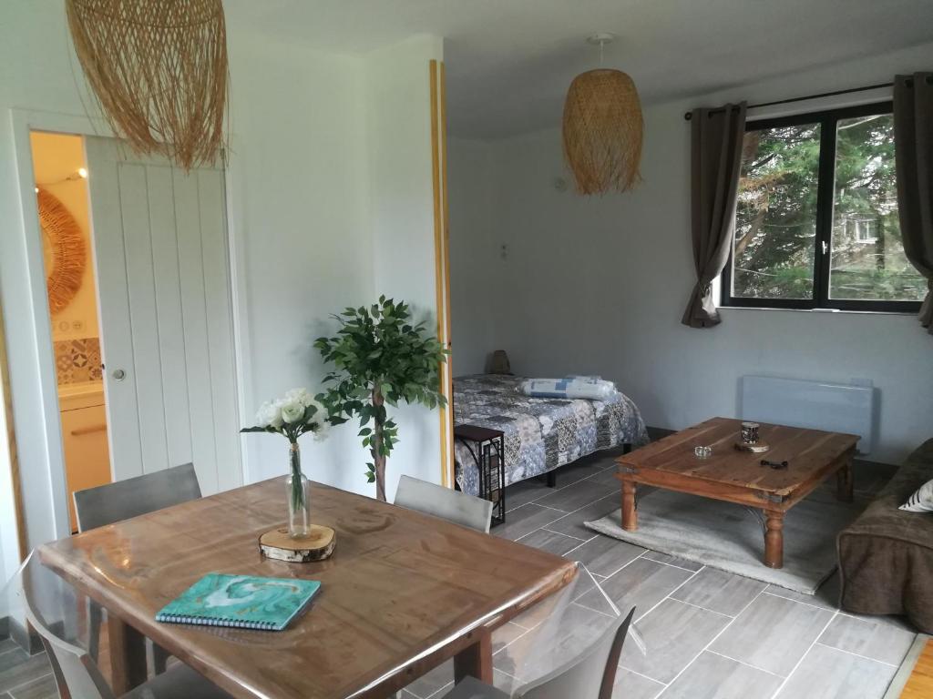 uma sala de estar com uma mesa e uma cama em Le Gîte insolite Gonnedouillé em Gonneville-en-Auge