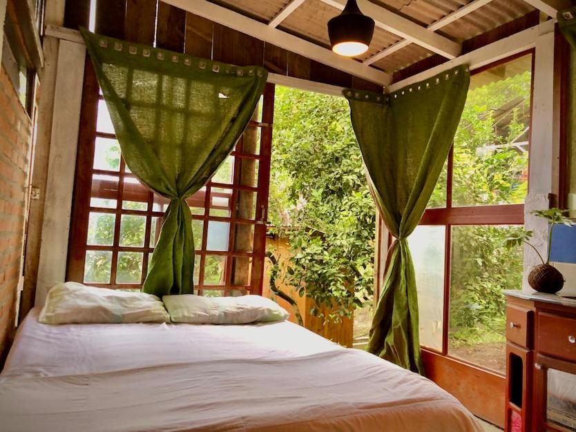 1 dormitorio con 1 cama frente a una ventana en Casa na Montanha Experiência na Natureza, en Florianópolis