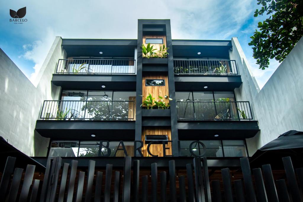 un edificio alto con balcones y plantas. en Barcelo Coliving, en Medellín