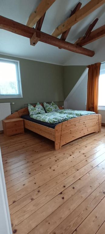 sypialnia z drewnianym łóżkiem na drewnianej podłodze w obiekcie Ferienhaus Familienzeit w mieście Schiefling am See
