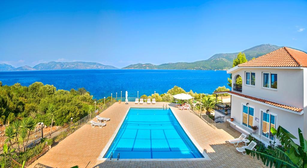 una imagen de una villa con piscina en Green Bay Hotel, en Karavomylos