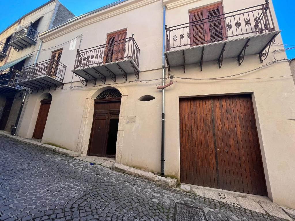 un edificio con dos puertas de garaje en una calle en Palazzo Triolo - Dimora di Charme, en Corleone