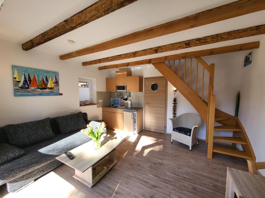 a living room with a couch and a staircase at Ab unters Reet in Born