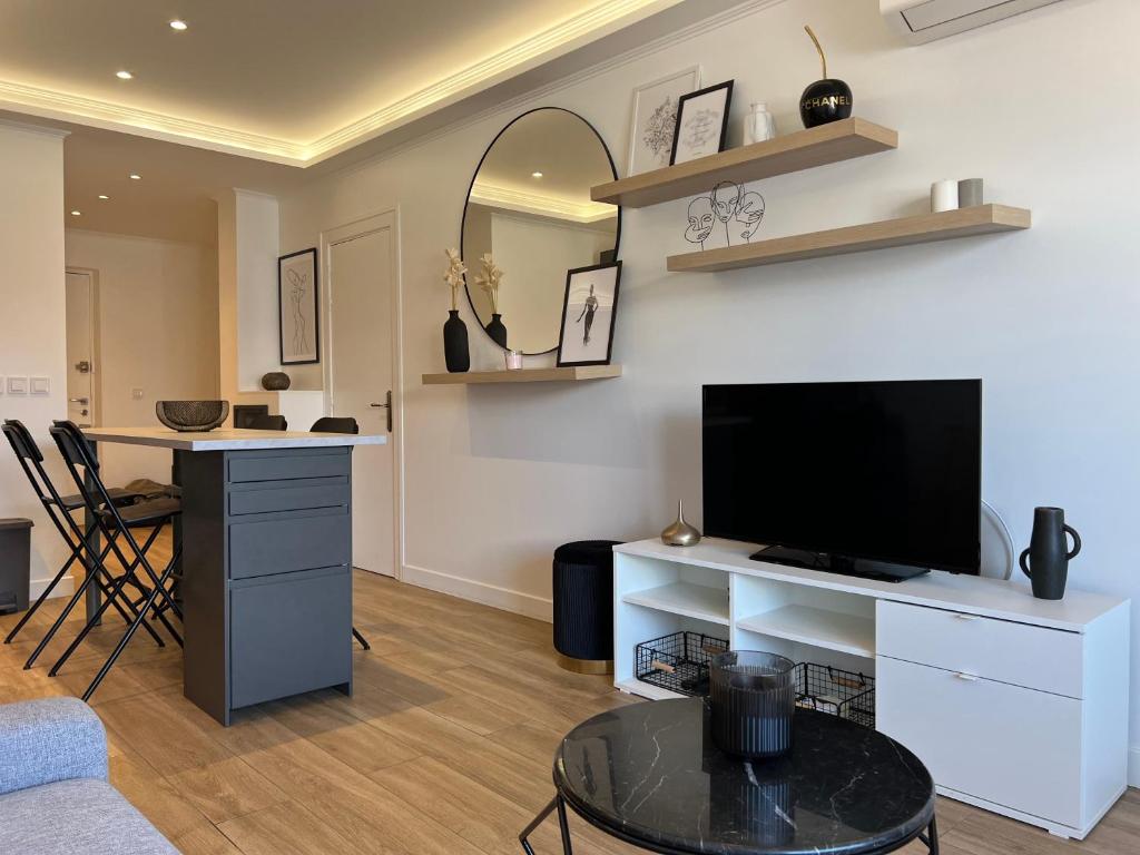 uma sala de estar com uma televisão e uma mesa em Cosy 2 bedrooms apartment Croisette em Cannes