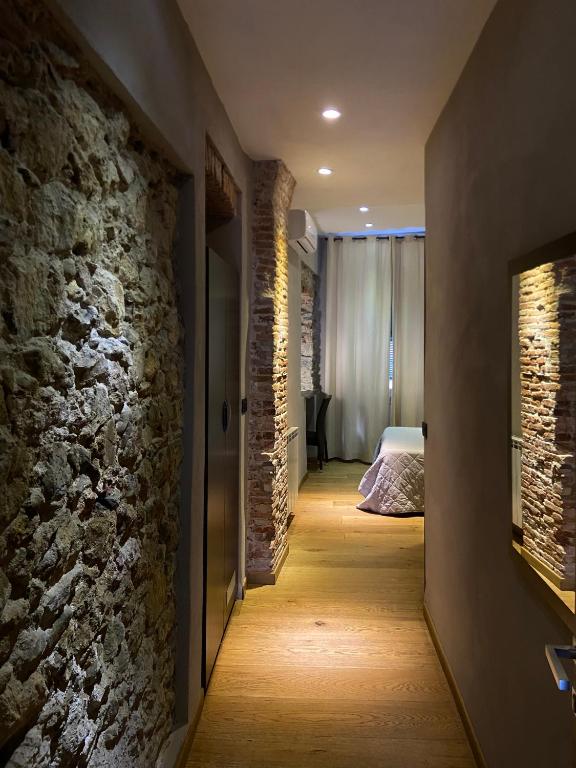 a hallway with a stone wall and a bedroom at Hotel Pino in Lerici