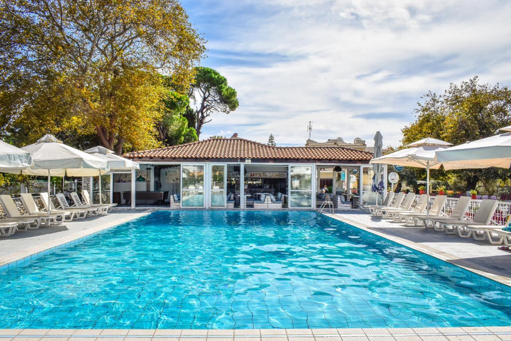 a swimming pool with chairs and a house at Koukias Village in Troulos