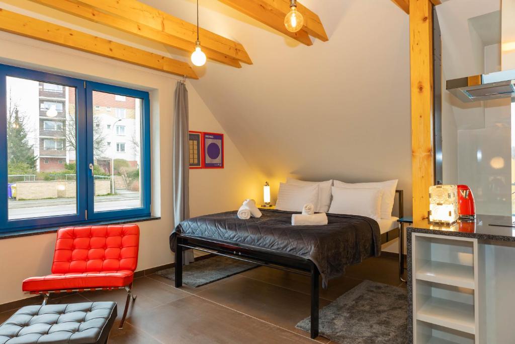 a bedroom with a bed and a red chair at Apartmány Kopacka in Svitavy