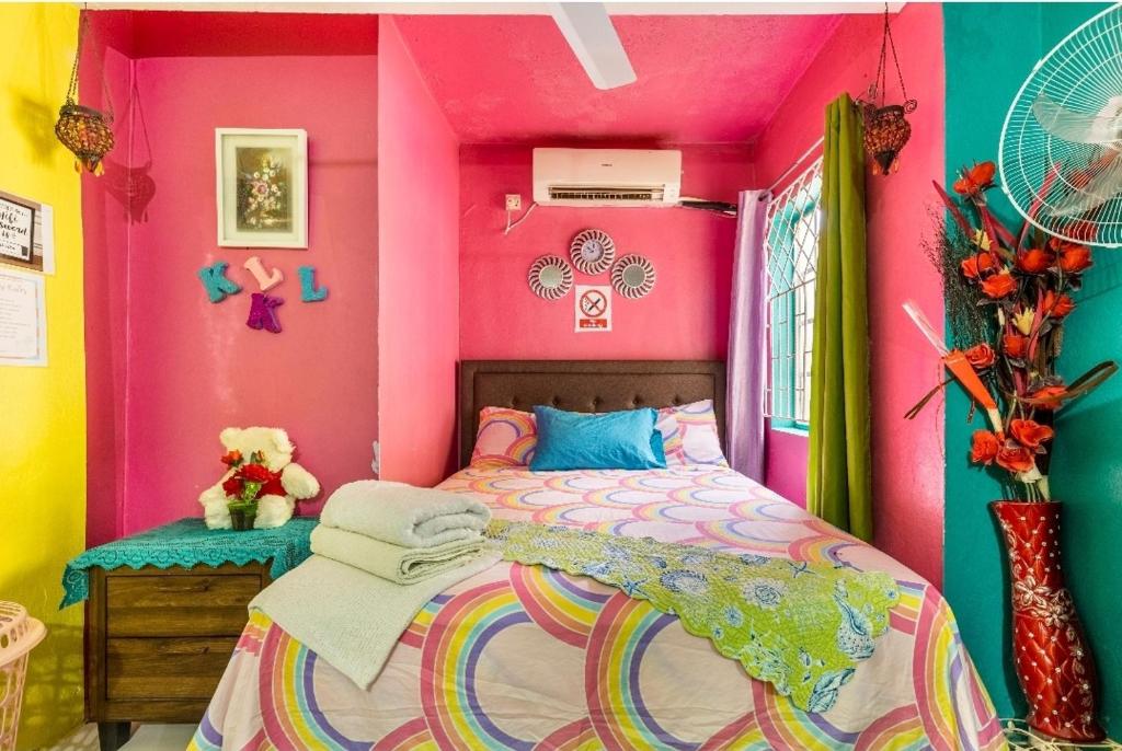 a colorful bedroom with a bed and a pink wall at Colorful Private Room Oasis in Montego Bay
