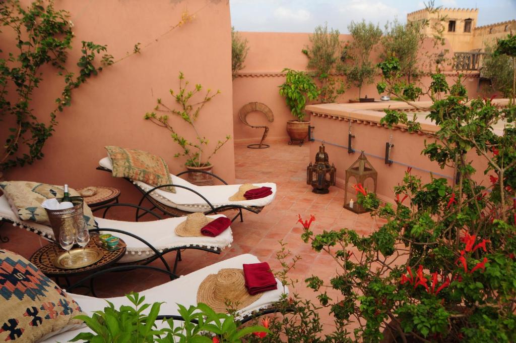 an outdoor patio with tables and chairs and trees at Riad Saba in Marrakesh