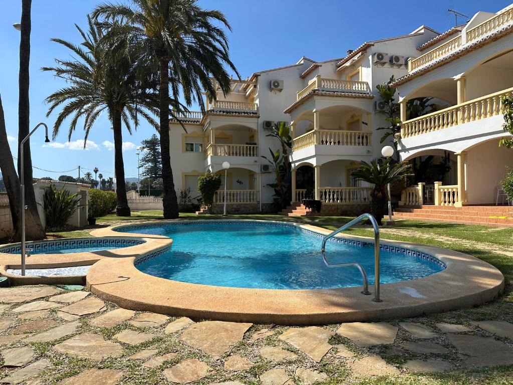 a swimming pool in front of a house at La Giralda in Denia