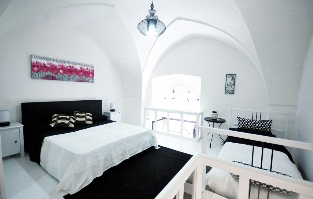 ガリポリにあるMaisonette B&Bの白いベッドルーム(ベッド1台、アーチ型の窓付)