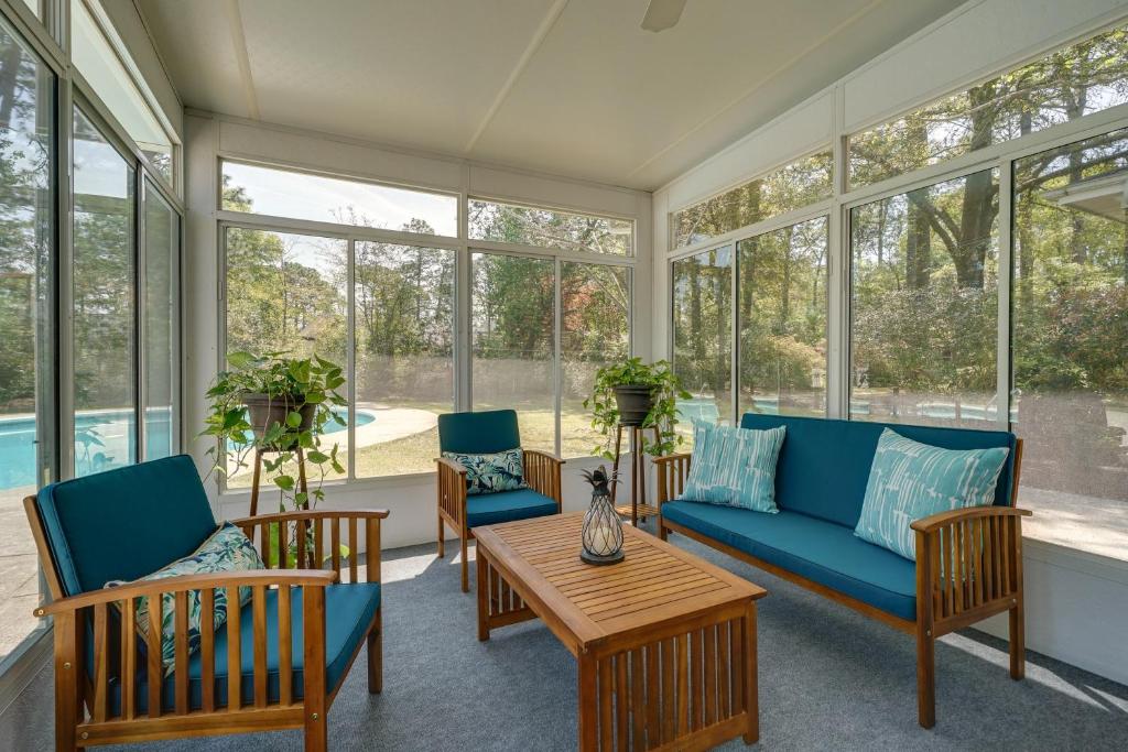 un porche cubierto con muebles y ventanas de color azul en Wilmington Rental about 4 Mi to Wrightsville Beach! en Wilmington