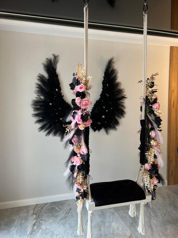 a swing with feathers and a black seat at Golden Life in Kielce