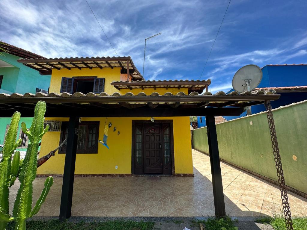 ein gelbes Haus mit einem Kaktus davor in der Unterkunft casa das bromelias prainha in Paraty