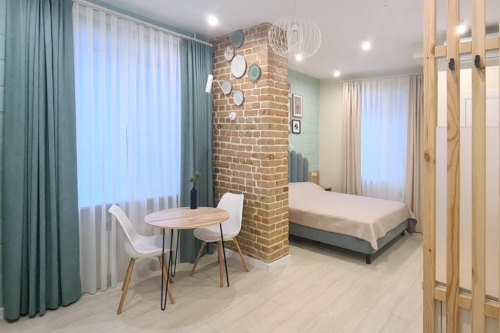 a bedroom with a bed and a table and chairs at Shevchenko Loft in Zaporozhye