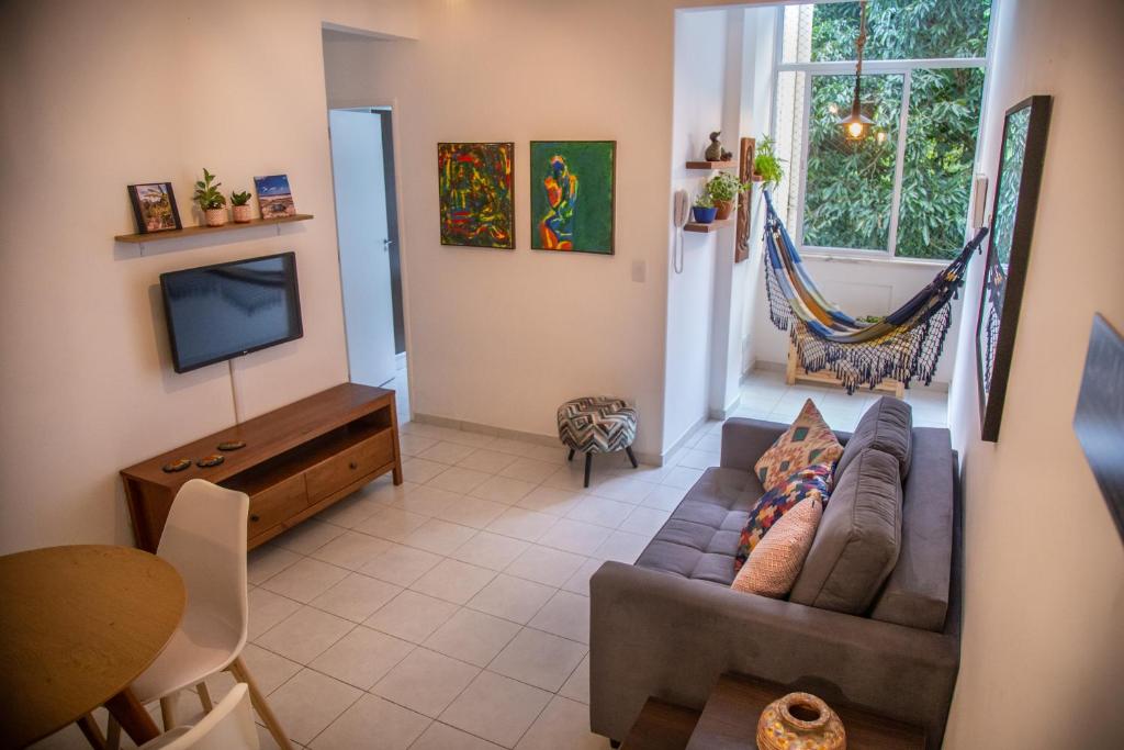 a living room with a couch and a television at Vista Verde Laranjeiras in Rio de Janeiro