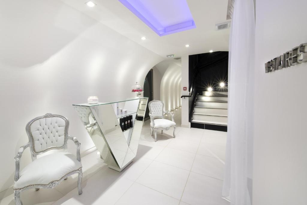 a white salon with two chairs and a mirror at Vertigo Hotel, By Marriott, a Member of Design Hotels in Dijon