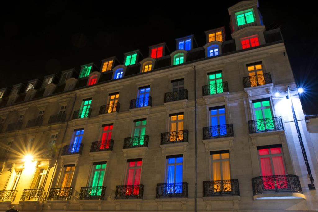 a building with colorful windows at night at Vertigo Hotel, By Marriott, a Member of Design Hotels in Dijon