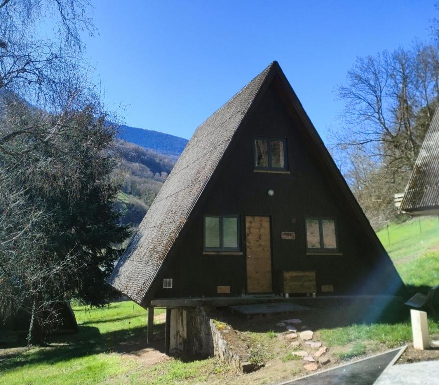 a black house with a thatched roof at Chalet bois Woody proche Luchon,Peyragudes,le mourtis in Cierp