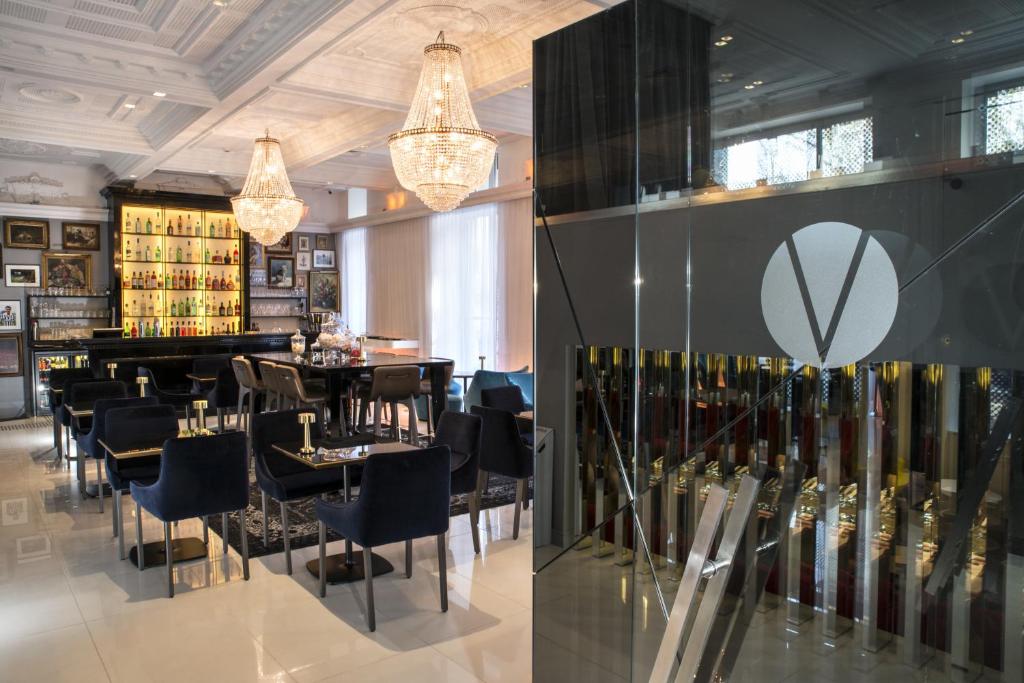 a restaurant with tables and chairs and a display of wine bottles at Vertigo Hotel, By Marriott, a Member of Design Hotels in Dijon