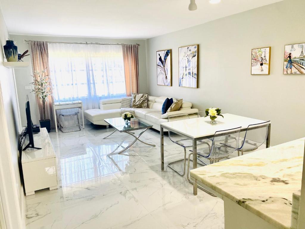 a living room with a couch and a table at Stylish 1BR Condo 1Block to Aventura Mall in Aventura