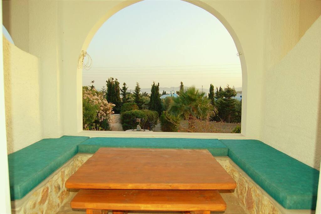 uma mesa num quarto com uma grande janela em Άνεσις διαμέρισμα στην Πάρο em Aliki