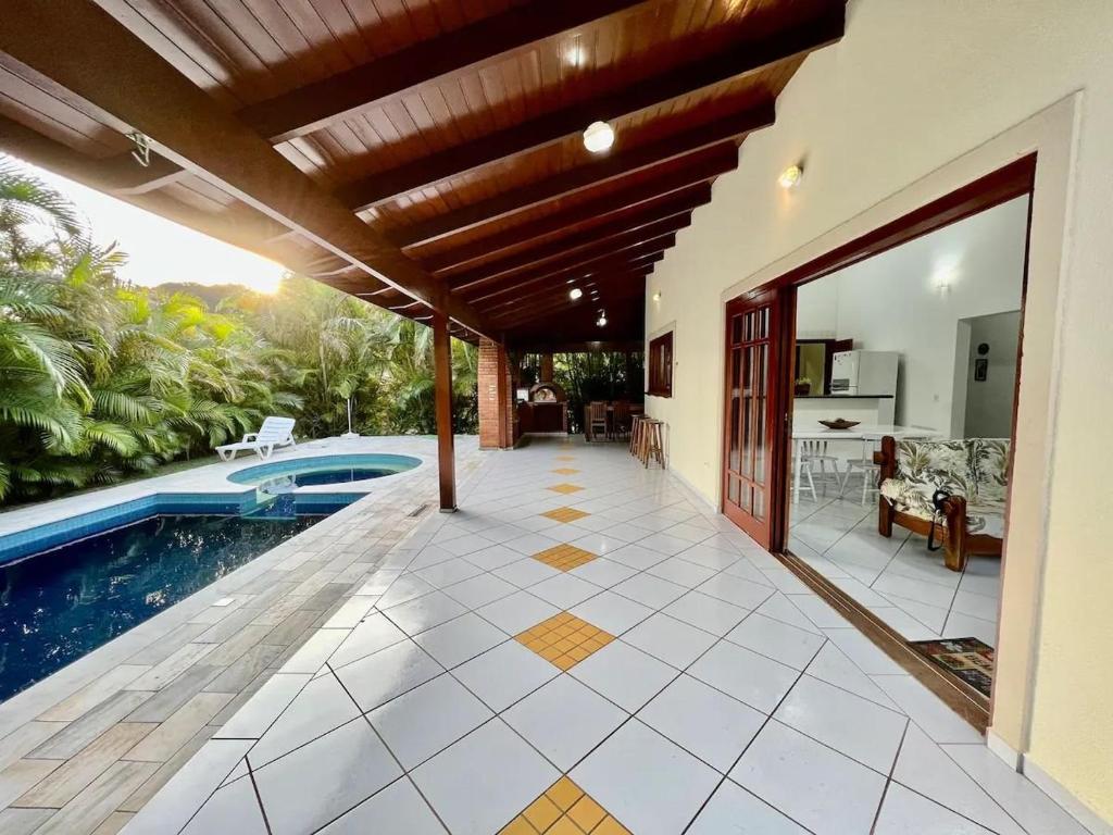 a house with a swimming pool and a patio at Casa com piscina privativa no Paúba um Vilarejo in São Sebastião