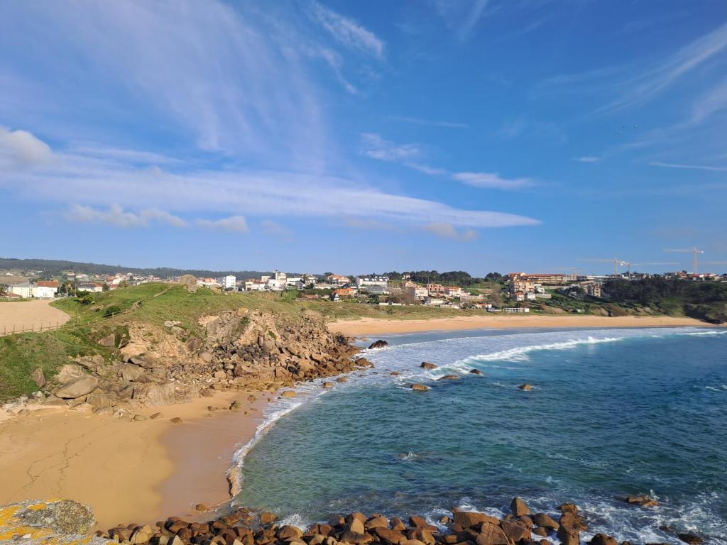 Blick auf einen Strand mit Felsen und das Meer in der Unterkunft Desconectaengalicia La Lanzada, 200m playa in A Lanzada