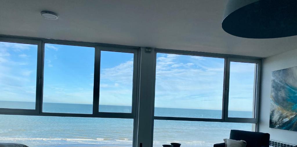 Cette chambre offre une vue sur l'océan depuis ses fenêtres. dans l'établissement Duplex frente al mar, à Monte Hermoso
