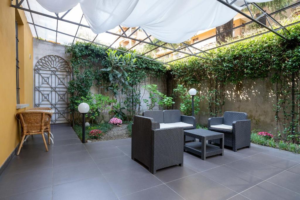 a patio with chairs and a greenhouse with plants at The Secret Garden in Como