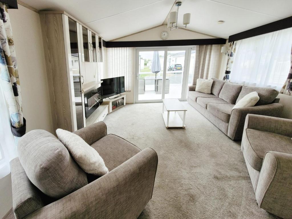 a living room with two couches and a television at Meadow Lodge in South Cerney