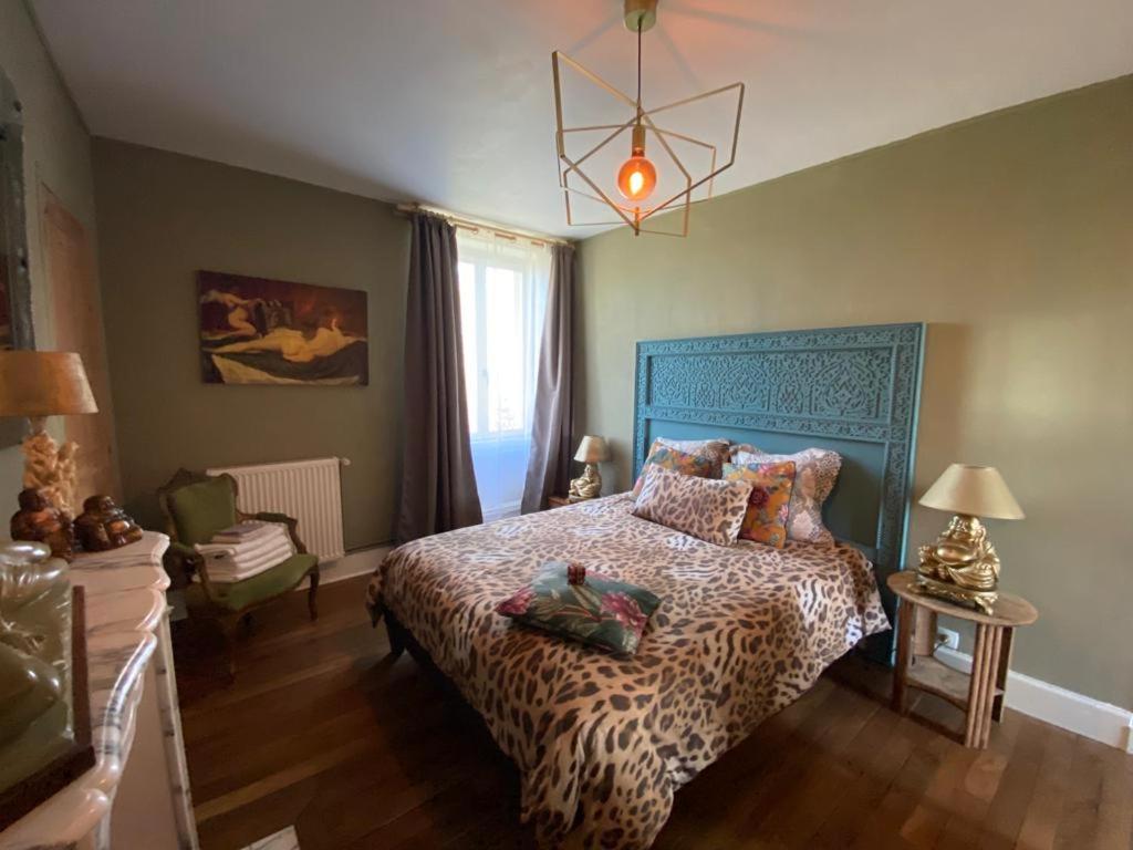- une chambre avec un lit orné d'une reproduction de guépard dans l'établissement Villa mon repos Annebecq, à Landelles-et-Coupigny