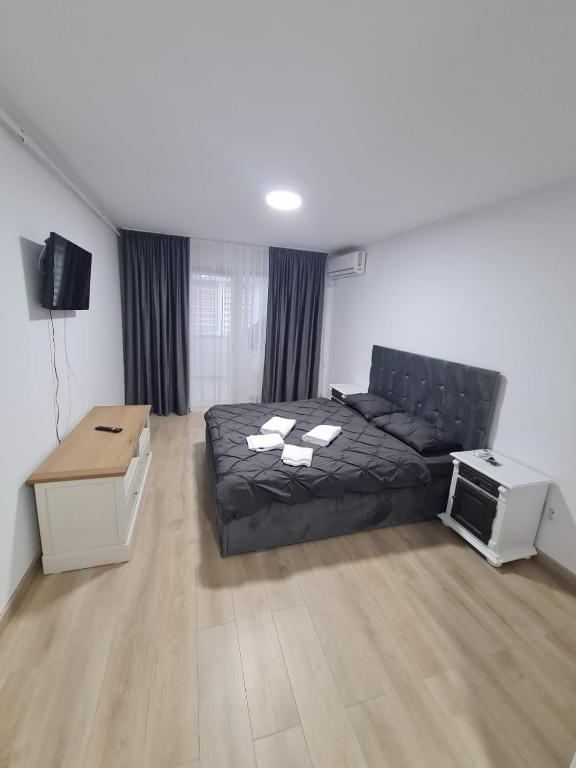 een slaapkamer met een zwart bed en een tv bij Garsoniera lux Lorena&Kevin in Piteşti